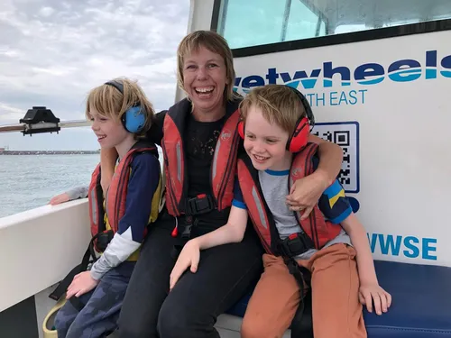 Sofia with her two children on a boat, all smiling