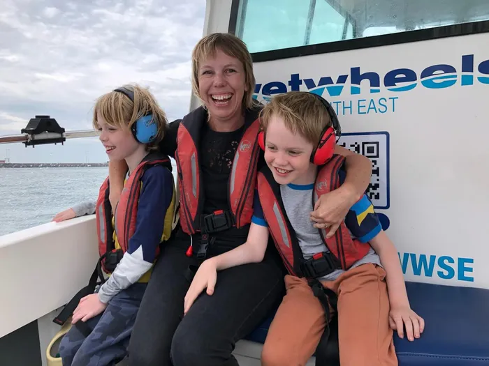 Sofia with her two children on a boat, all smiling