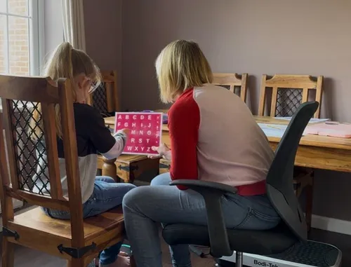 Sofia working with a child speller at a letterboard